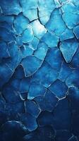 Cracked blue ice surface showcasing intricate patterns and textures in natural light photo