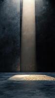 Shimmering light beams illuminate a textured surface revealing scattered pebbles in a dark setting photo