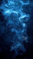 Swirling blue smoke creates a mystical atmosphere in a dark background illuminated with soft light photo