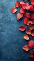 Beautiful red autumn leaves on a textured blue background creating a striking contrast and seasonal ambiance photo