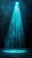 Bright blue spotlight illuminates a dark stage creating a dramatic atmosphere for performance in an indoor venue photo