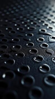 de cerca ver de texturizado negro superficie con gotas reflejando ligero y creando un único modelo foto