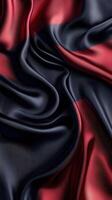 Silk fabric draped in deep red and black colors showcasing elegant texture and sheen in soft lighting photo