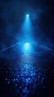 Mysterious blue light illuminating a wet road at night with fog hovering in the atmosphere photo
