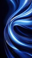 Fluid motion of vibrant blue waves creates an abstract visual experience in a dark setting photo