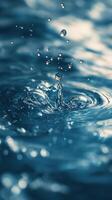 Water droplets create ripples and splashes in a serene blue environment during daylight photo