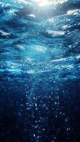 Bubbles rising through crystal clear water illuminated by sunlight at midday photo