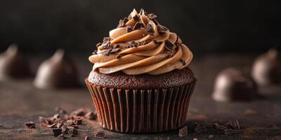 Delicious chocolate cupcake topped with creamy frosting and chocolate shavings in a dark setting photo