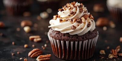 Rich chocolate cupcake topped with creamy frosting and crushed pecans on a dark surface photo