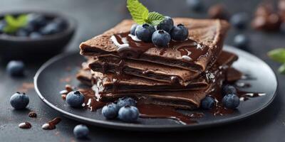 Delicious chocolate crepes served with fresh blueberries and mint in a stylish setting photo