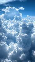 Fluffy white clouds blanket the sky on a bright sunny day with a hint of blue peeking through photo