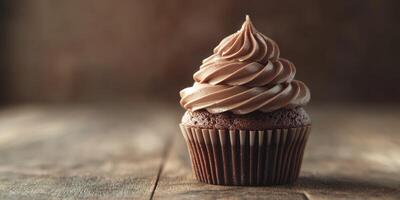 Delicious chocolate cupcake with swirled frosting on wooden table photo