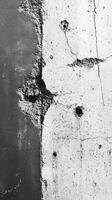 Cracked concrete wall showcasing textures and imperfections in black and white photo