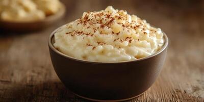 Creamy rice pudding topped with chocolate shavings served in a rustic bowl on a wooden table photo