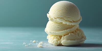 Vanilla ice cream scoops stacked on a light blue surface with scattered crumbs photo