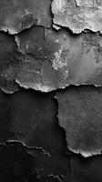 Close-up view of weathered black and grey textured surface with peeling layers revealing different patterns photo