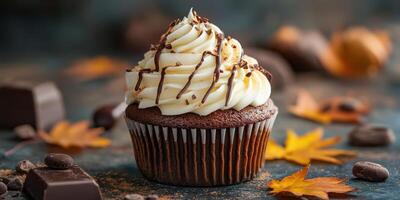 Delicious chocolate cupcake topped with creamy frosting and decorated with chocolate drizzle and autumn leaves photo