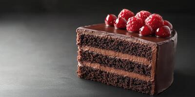 Decadent chocolate cake layered with rich frosting and topped with fresh raspberries on a dark background photo