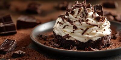 Decadent chocolate dessert topped with whipped cream and chocolate shavings on a dark plate photo