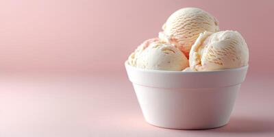 Creamy vanilla ice cream scoops in a white bowl on a soft pink background photo