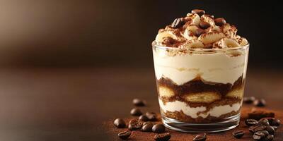 Delicious dessert layered with coffee-soaked biscuits and creamy mascarpone served in a glass photo