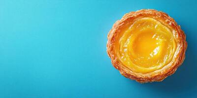 Delicious custard tart showcasing a golden filling on a vibrant blue background photo