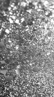 Shimmering silver glitter scattered across a surface in a dazzling display of light and reflection photo