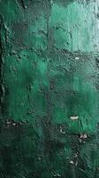 Textured green wall exhibiting layers and imperfections in urban setting photo