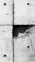 Concrete wall with damage showcasing texture, holes, and structural wear in an urban setting photo