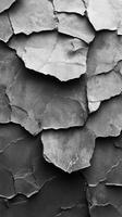 Textured layers of cracked gray stone showcase natural patterns and unique formations in a monochromatic setting photo