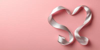Elegant pink ribbon shaped into heart design on soft pastel background for decorative purposes photo
