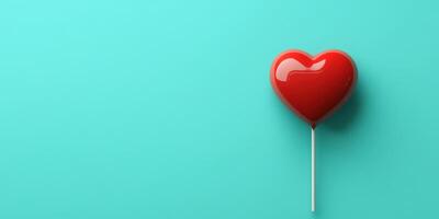 Red heart-shaped lollipop on a turquoise background showcasing a sweet treat perfect for celebrations or gifts photo