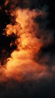 Wisps of orange and gray smoke rise dramatically in a dark space, creating a captivating visual effect photo