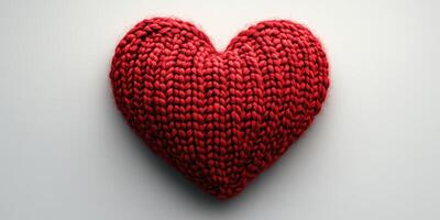Knitted red heart on a plain background symbolizes love and care in an artistic display of craftsmanship and creativity photo
