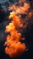 Colorful orange smoke rising gracefully in a dark setting, creating a striking visual display photo