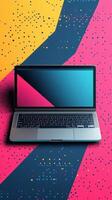 Laptop placed on vibrant geometric background featuring bold colors and patterns for creative workspace inspiration photo