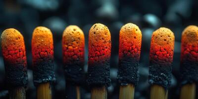 Row of burning matches with glowing tips creating a striking visual against a dark background photo