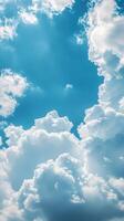 Expansive blue sky filled with fluffy white clouds during midday with bright sunshine illuminating the scene photo