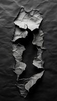 Torn black paper revealing a textured surface underneath in a creative art composition photo