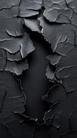 Creative black textured paper with torn edges revealing a dark background in a minimalist design photo