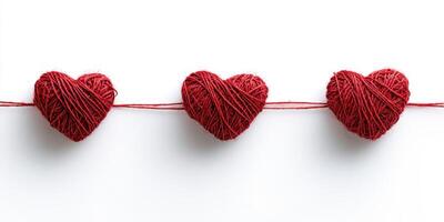 Red yarn hearts connected by string, showcasing creativity and affection in a minimalist design photo