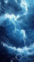 Enormous waves crash in deep blue ocean creating swirling patterns at daylight photo