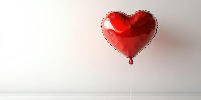 Heart-shaped red balloon floats against a plain white background adding a touch of romance to the setting photo