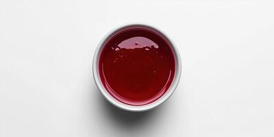 Vibrant red sauce in a white bowl on a plain background, perfect for adding flavor to dishes and enhancing presentation photo