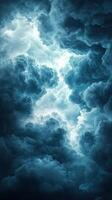 Dark clouds swirl gracefully in a tumultuous sky illuminated by flashes of bright light during a storm at dusk photo
