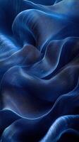 Elegant blue fabric draping with soft waves and gentle light creating a serene texture and depth photo