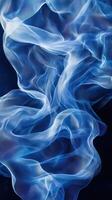Soft blue fabric waves create a mesmerizing abstract pattern against a dark background in this serene artistic display photo