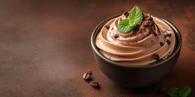 Delicious chocolate mousse topped with mint and chocolate shavings in a bowl on a rustic surface photo