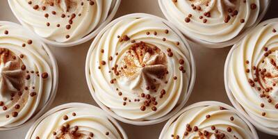 Delicious cupcakes with creamy frosting and chocolate sprinkles arranged in a circular pattern on a table photo
