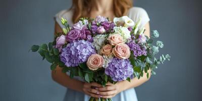 Beautiful floral bouquet featuring hydrangeas, roses, and calla lilies held by a woman in a softly lit setting photo